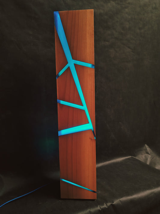 Una lampada da terra dal design slanciato, impreziosita da sottili inserti in resina blu che creano suggestivi giochi di luce.